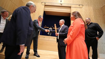 Bundeskanzler Olaf Scholz (SPD) hat vom Mitgründer der Jüdischen Landesgemeinde, Alexander Kogan, die Ester-Rolle für das neue Synygogenzentrum. Scholz besuchte den Neubau gemeinsam mit Kulturministerin Manja Schüle (SPD).