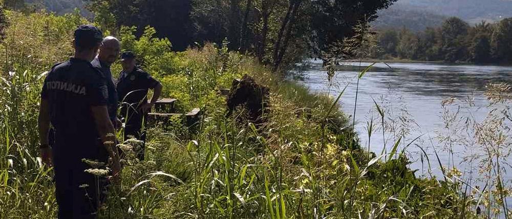 Polizisten suchen das Ufer ab, nachdem ein Flüchtlingsboot mit mehreren Migranten auf der Drina gekentert war.