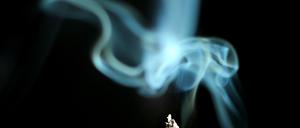 Der Rauch einer brennenden Zigarette. Ein Drittel der Deutschen ist Raucher.