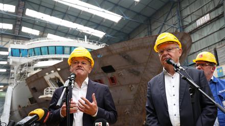 Bundeskanzler Olaf Scholz (SPD, l) und Stephan Weil (SPD), Ministerpräsident von Niedersachsen, geben in einer Werkshalle der Meyer Werft ein Presse-Statement ab. Im Hintergrund der Betriebsratsvorsitzende der Meyer-Werft, Andreas Hensen. 