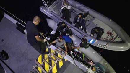 Migranten gehen an Bord der griechischen Küstenwache. 