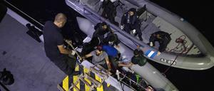 Migranten gehen an Bord der griechischen Küstenwache. 