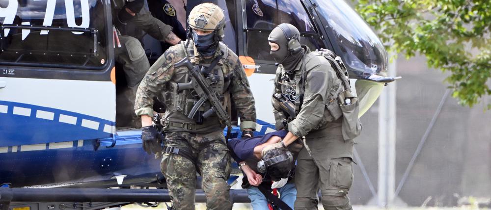 Der mutmaßliche Täter des Messerangriffs von Solingen wird von einem Hubschrauber zu einer Wagenkolonne geführt. Diese bringt ihn zum Ermittlungsrichter des Bundesgerichtshof (BGH), der über einen Haftbefehl entscheiden wird.