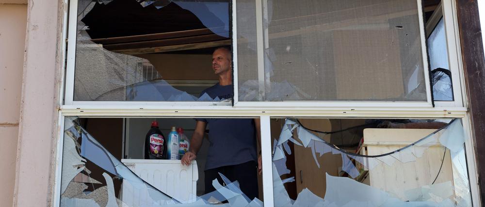 Ein Mann steht am Fenster, was durch Raketen Raketen der libanesischen Hisbollah zerstört wurde.