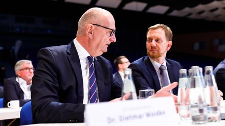 Die beiden Ministerpräsidenten Dietmar Woidke Brandenburg, SPD und Michael Kretschmer Sachsen, CDU unterhalten sich am Rande einer Konferenz.