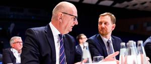 Die beiden Ministerpräsidenten Dietmar Woidke Brandenburg, SPD und Michael Kretschmer Sachsen, CDU unterhalten sich am Rande einer Konferenz.