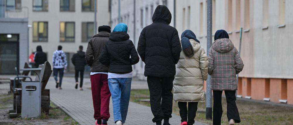 Migranten gehen über das Gelände der Zentralen Erstaufnahmeeinrichtung für Asylbewerber in Brandenburg.