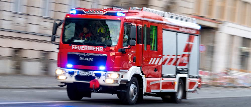 Ein Feuerwehrauto mit eingeschaltetem Blaulicht fährt zum Einsatz.