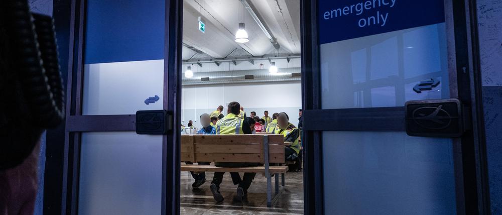 Polizeibeamte warten mit Afghanen auf dem Flughafen Leipzig-Halle in einer Wartehalle. 45 abgelehnte Asylbewerber wurden mit dem Sonderflug in Afghanistans Hauptstadt Kabul abgeschoben. (Foto: Archiv, 2019)