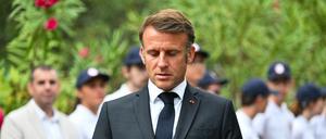 Der französische Präsident Emmanuel Macron betrachtet zwei Smartphones während einer Zeremonie zum 80. Jahrestag der Landung der Alliierten in der Provence während des Zweiten Weltkriegs auf dem Nationalfriedhof Boulouris.