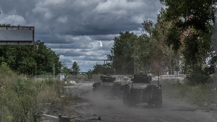 Ukrainische Soldaten fahren mit Militärfahrzeugen an einem Grenzübergang zu Russland (Symbolbild).