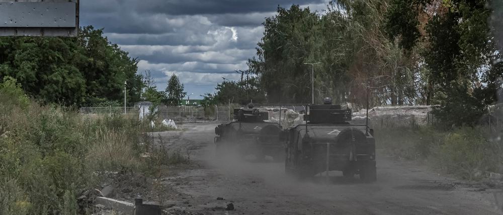Ukrainische Soldaten fahren mit Militärfahrzeugen an einem Grenzübergang zu Russland (Symbolbild).