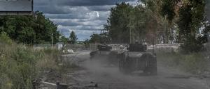 Ukrainische Soldaten fahren mit Militärfahrzeugen an einem Grenzübergang zu Russland (Symbolbild).