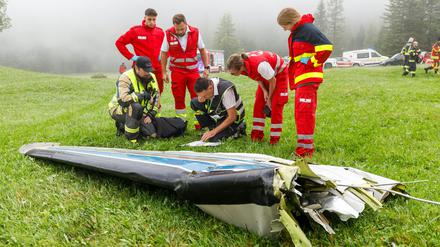Einsatzkräfte begutachten Wrackteile nach dem Flugzeugabsturz.