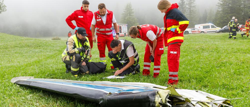 Einsatzkräfte begutachten Wrackteile nach dem Flugzeugabsturz. 