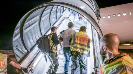 Polizeibeamte begleiten einen Afghanen auf dem Flughafen Leipzig-Halle in ein Charterflugzeug (Symbolbild).