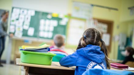 Schülerinnen und Schüler einer Grundschule sitzen in ihrem Klassenraum.