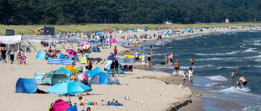Badegäste genießen am Ostseestrand der Insel Rügen das Sommerwetter.