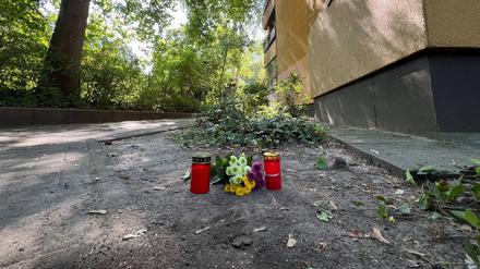 Vor dem Haus in Zehlendorf erinnern Grablichter und Blumen an die getötete Frau.