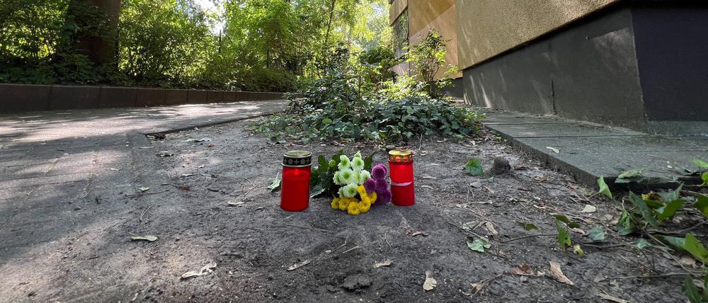 Vor dem Haus in Zehlendorf erinnern Grablichter und Blumen an die getötete Frau.