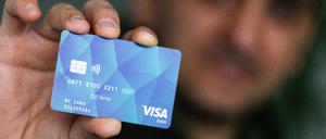 Eine Person hält eine Debitcard in der Hand. 