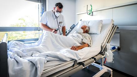 Ein Pfleger kümmert sich um einen Patienten. 