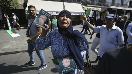 Anhänger des algerischen Präsidenten verteilen Handzettel für die Wiederwahl Tebbounes.