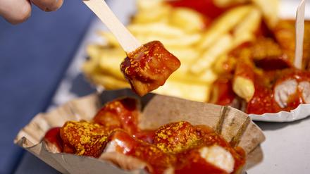 PRODUKTION - 28.08.2024, Berlin: Eine Person spießt ein Stück Currywurst auf. Der 75. Jahrestag der Erfindung der Currywurst ist am 04.09. (zu dpa: «Vom Imbiss zum Kult-Snack: Ein Wettstreit um die Currywurst») Foto: Fabian Sommer/dpa +++ dpa-Bildfunk +++