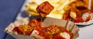 PRODUKTION - 28.08.2024, Berlin: Eine Person spießt ein Stück Currywurst auf. Der 75. Jahrestag der Erfindung der Currywurst ist am 04.09. (zu dpa: «Vom Imbiss zum Kult-Snack: Ein Wettstreit um die Currywurst») Foto: Fabian Sommer/dpa +++ dpa-Bildfunk +++