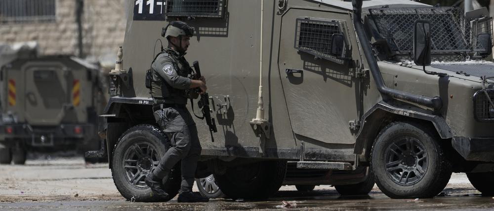 Ein Angehöriger der israelischen Streitkräfte geht neben einem gepanzerten Fahrzeug während einer Militäroperation im Westjordanland (Symbolbild).