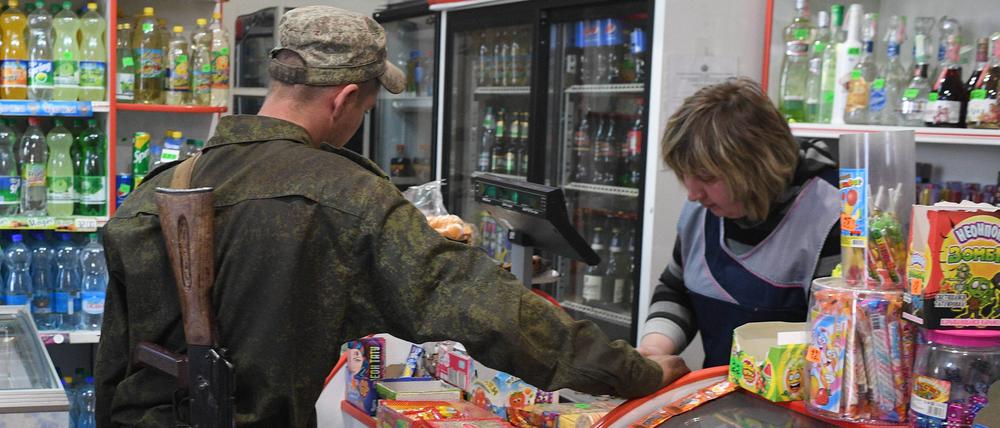 Ein Soldat der LPR-Volksmiliz kauft in der Stadt Pervomaisk in Luhansk Lebensmittel ein (Symbolbild).