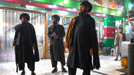 Taliban security personnel stand outside a restaurant in Kandahar on August 25, 2024. (Photo by Wakil Kohsar / AFP)