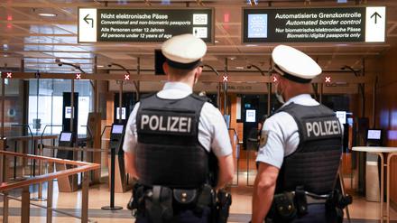Beamte der Bundespolizei warten an der Einreisekontrolle auf ankommende Passagiere 