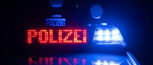  Zwei Polizisten stehen vor einem Polizeifahrzeug 