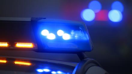Ein Polizeiauto mit eingeschaltetem Blaulicht steht an einer Unfallstelle. (Symbolbild)