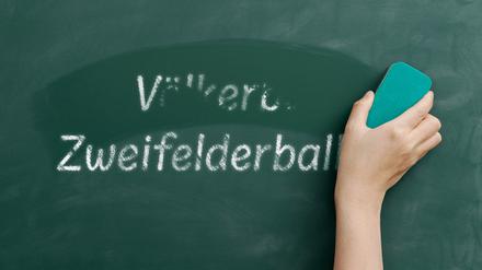 Mit einem Schwamm wird der Begriff „Völkerball“ von einer Tafel weggewischt. Darunter steht „Zweifelderball“.