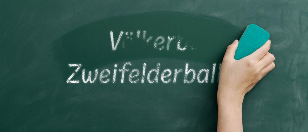 Mit einem Schwamm wird der Begriff „Völkerball“ von einer Tafel weggewischt. Darunter steht „Zweifelderball“.