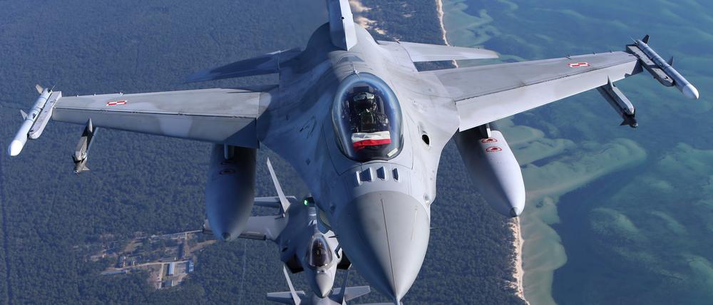 Ein Kampfflugzeug vom Typ Lockheed Martin F-16 Fighting Falcon der polnischen Luftwaffe bei einer Übung mit F-35A der niederländischen Luftwaffe unten.