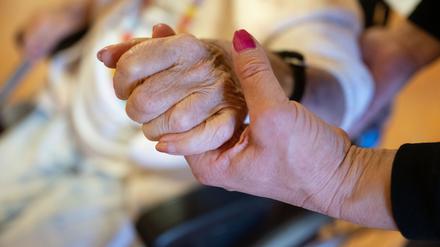 Eine Physiotherapeutin hält die Hand einer Pflegeheimbewohnerin. (Symbolfoto)