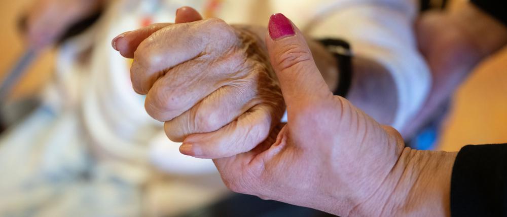 Eine Physiotherapeutin hält die Hand einer Pflegeheimbewohnerin. (Symbolfoto)
