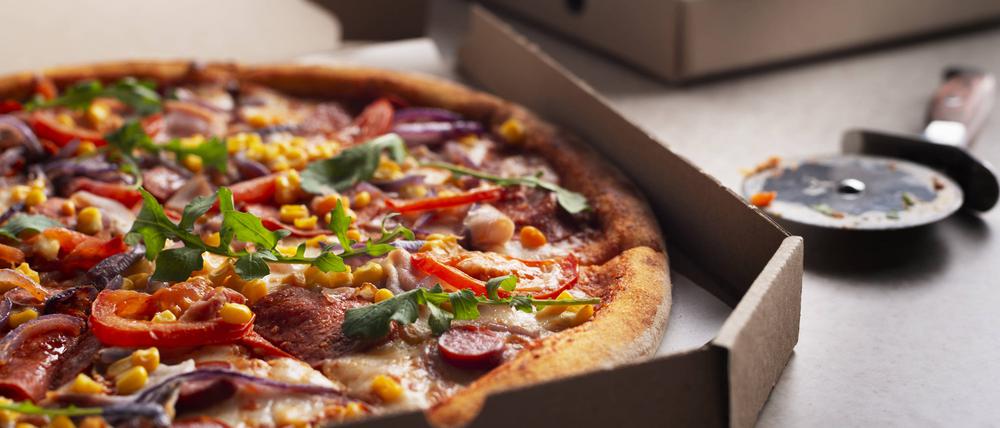 Large Pizza in open carton box and cutter on kitchen table closeup view Large Pizza in open carton box and cutter on kitchen table closeup view Copyright: xZoonar.com/OlenaxMykhaylovax 21034229