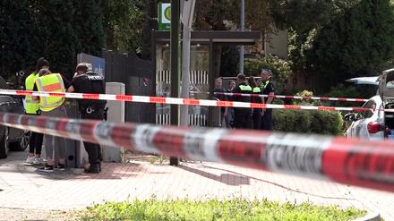 Polizisten stehen hinter Absperrband am Tatort im Bereich der Bahnhofstraße in Sarstedt.