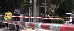 Polizisten stehen hinter Absperrband am Tatort im Bereich der Bahnhofstraße in Sarstedt.