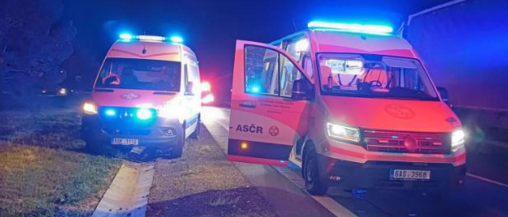 Einsatzwagen des tschechischen Samariterbundes stehen am Rand einer Autobahn.