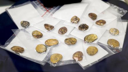 Sichergestellte Münzklumpen werden während einer Pressekonferenz des Bayerischen Landeskriminalamts zu den Festnahmen im Fall des Manchinger Goldschatz-Diebstahls präsentiert (Archivbild).
