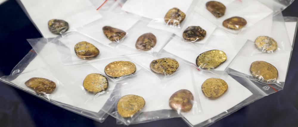 Sichergestellte Münzklumpen werden während einer Pressekonferenz des Bayerischen Landeskriminalamts zu den Festnahmen im Fall des Manchinger Goldschatz-Diebstahls präsentiert (Archivbild).