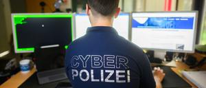 Ein Polizist steht mit einem Poloshirt mit Aufschrift ·Cyber Polizei·.