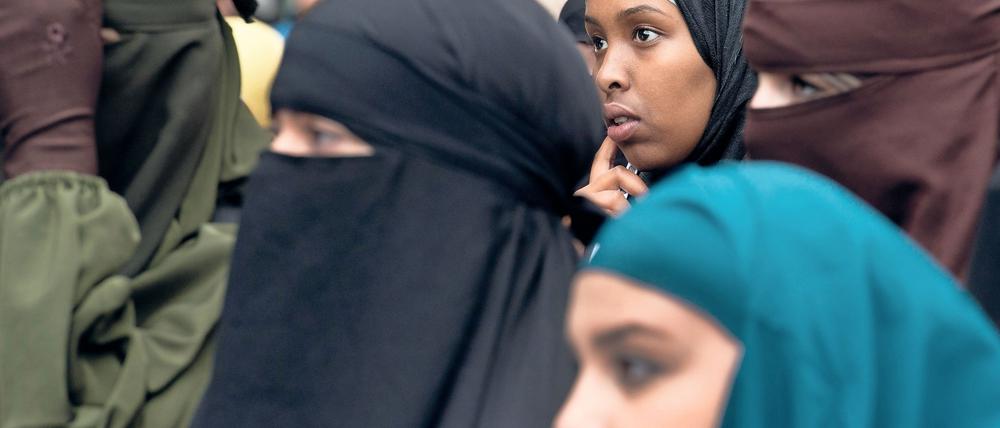 Mit Kopftuch oder Burka verschleierte Frauen.