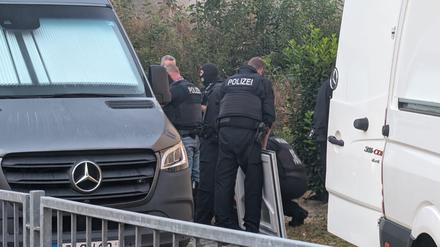 Polizeibeamte durchsuchen ein Gelände und Räume in Jena bei einer Schleuserrazzia.