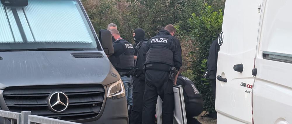 Polizeibeamte durchsuchen ein Gelände und Räume in Jena bei einer Schleuserrazzia.